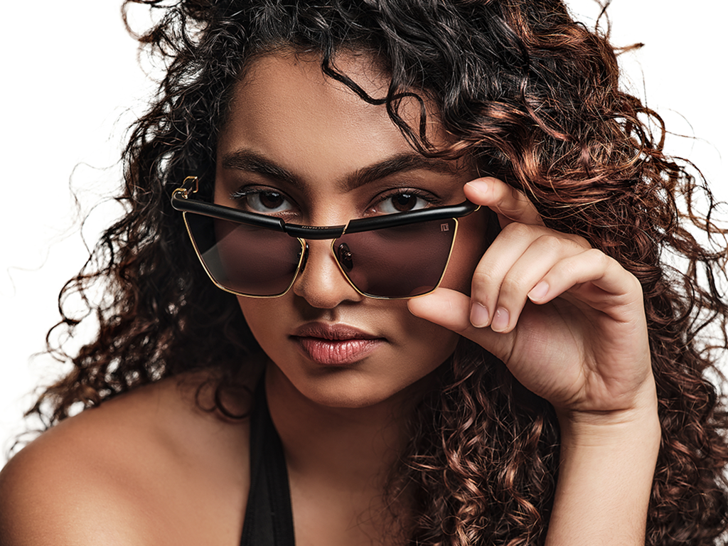 Woman with curly wearing luxurious black cat-eye sunglasses.